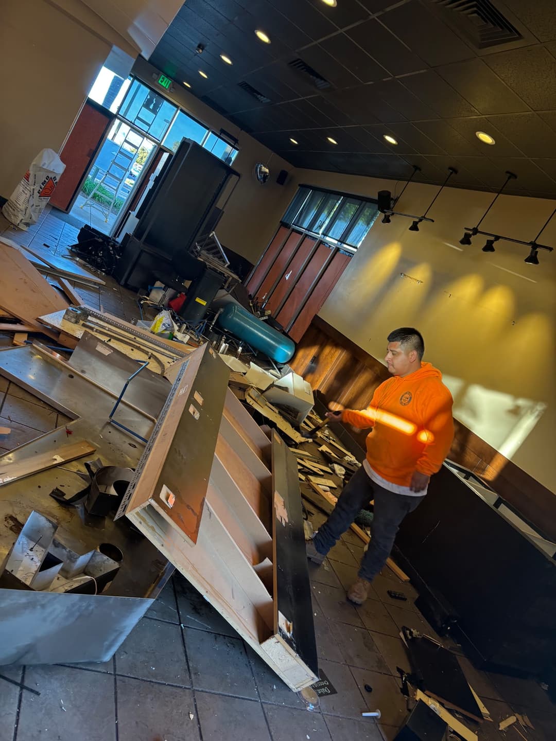 Commercial junk removal worker dismantling fixtures during interior retail cleanout